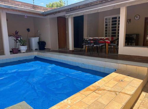 Casa inteira com três quartos, piscina climatizada por energia solar e área de churrasqueira